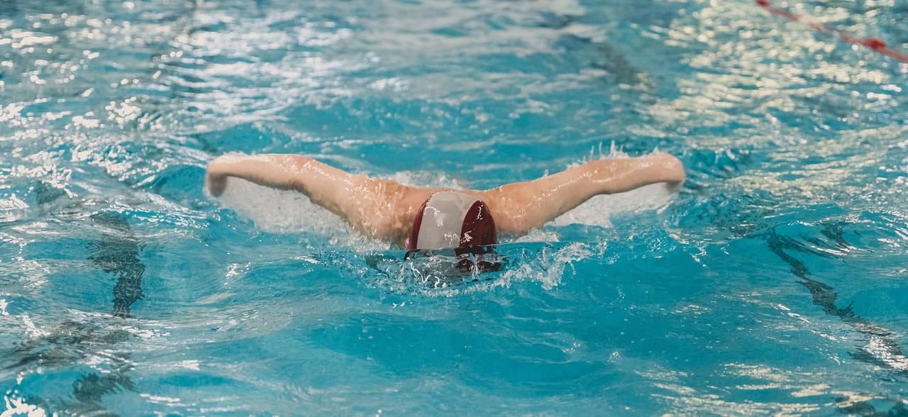 Child learning to swim with professional instruction